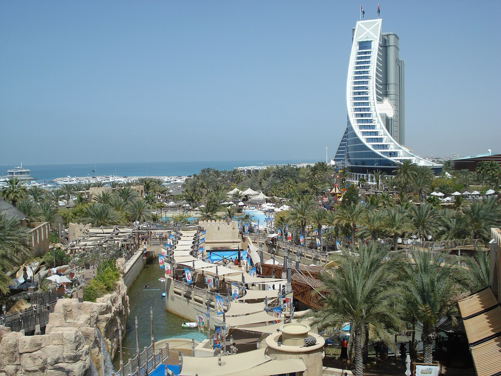 Отель Jumeirah Beach Hotel в форме волны среди пальм на побережье Дубая